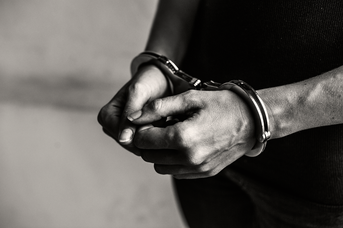 Airport arrest with handcuffs — warrant and INTERPOL Red Notice enforcement